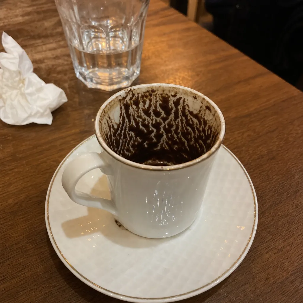 A Turkish coffee cup with grounds settled into a pattern