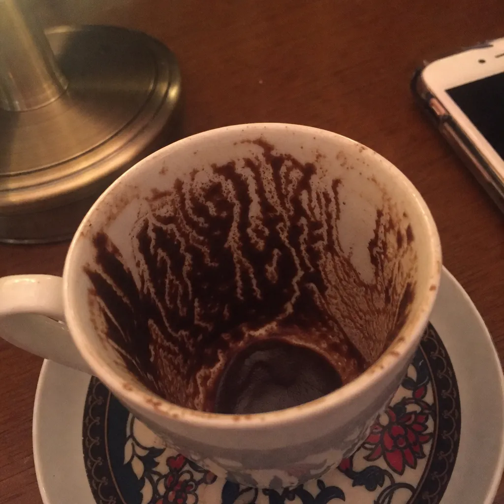 A Turkish coffee cup with grounds settled into a pattern